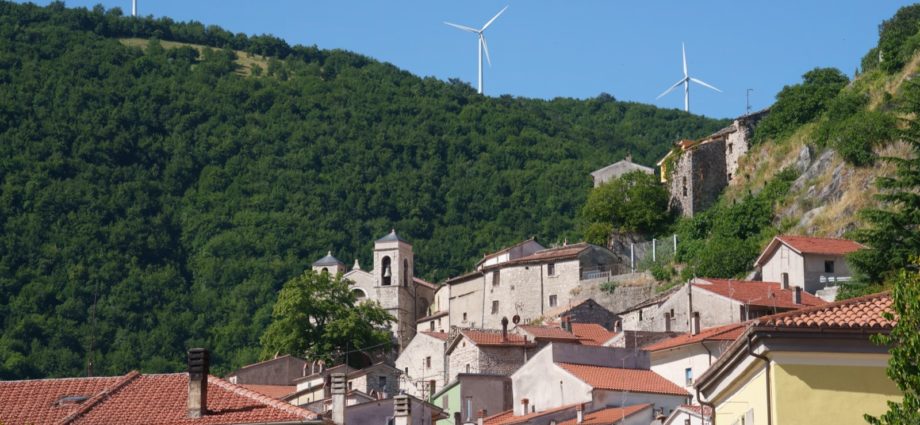 Turbine eoliche sopra la collina di un borgo